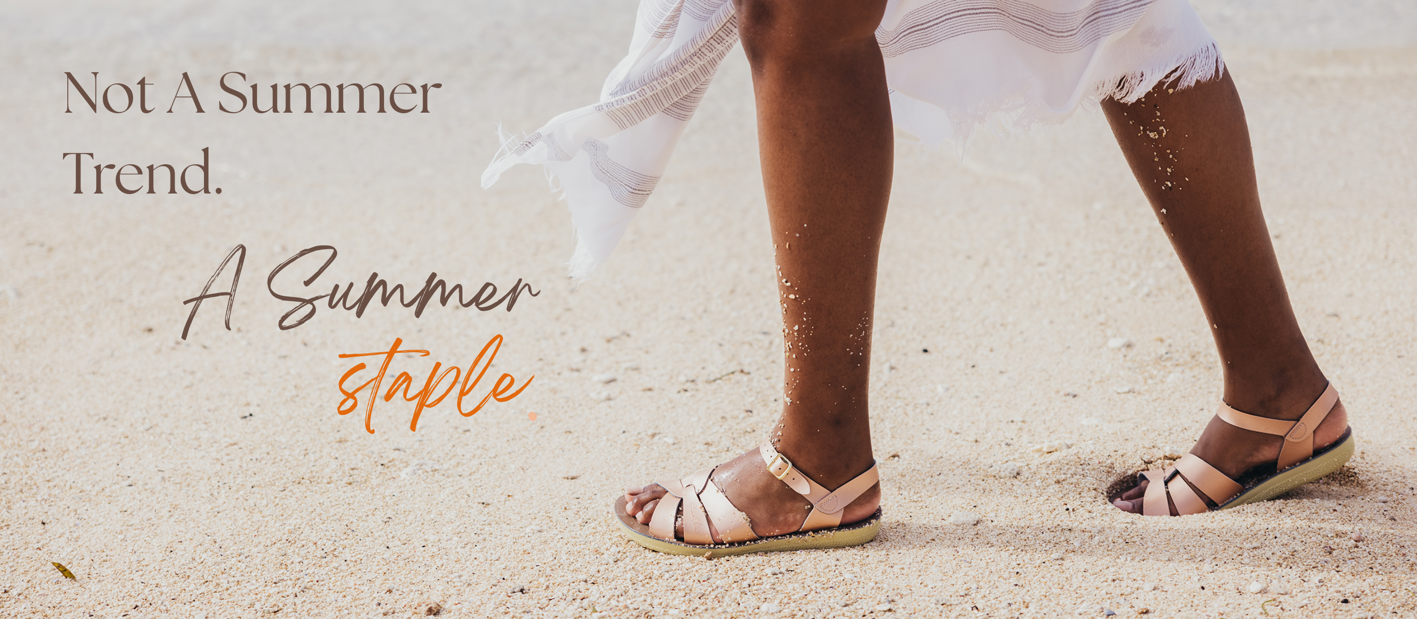 Person wearing rose gold salt-water sandals on a sandy beach with text about summer fashion.